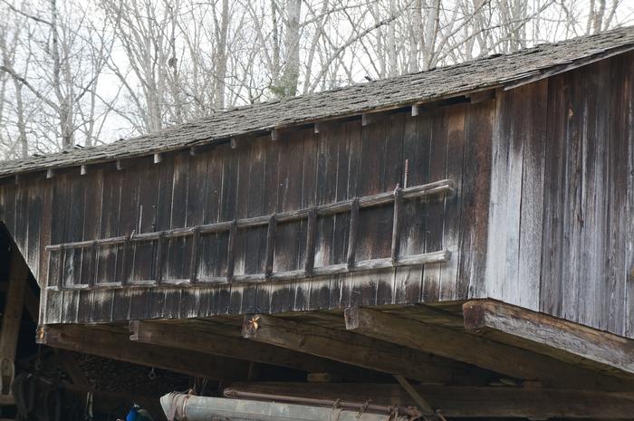 The barn's eaves cover up vents for stack cooling while a ladder is hung on its siding.