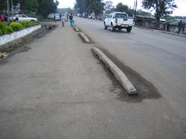 This footway adjacent to a road in Tanzania is protected by curb pieces which separate motor traffic from pedestrians and bicycles. Such basic safety measures are needed to prevent pedestrian injuries along roadways in many countries.