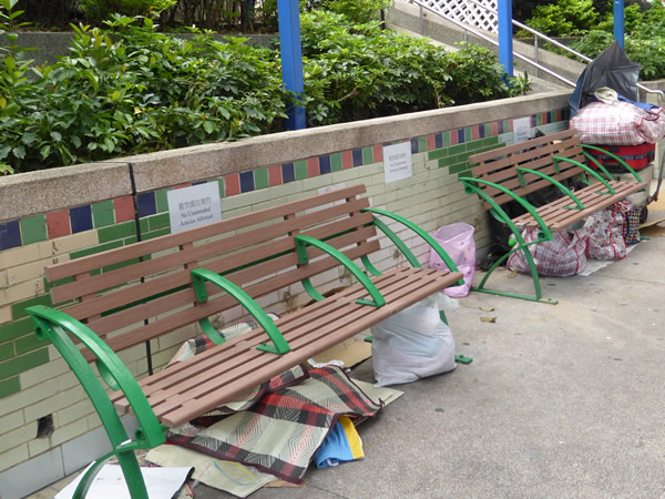 Park benches serve as “home” for those without shelter, each of whom neatly stack their belongings beneath their chosen spot in Hong Kong.  Photo by Benjamin Clavan, 2015.