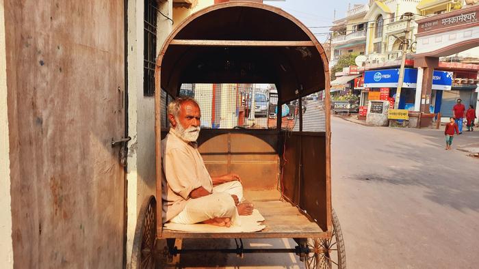 This photograph depicts the tragic irony of life, a rickshaw which once served as the source of income has now become the sole livelihood for Hariram, a 68-year-old resident. There are many such elderly who have lost their homes and now seek temporary shelters around the temple. 